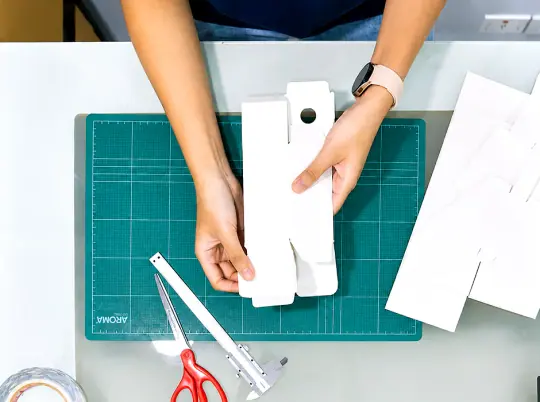 กล่องไดคัทสีขาวหลายรูปทรงบนแบบร่าง dieline
